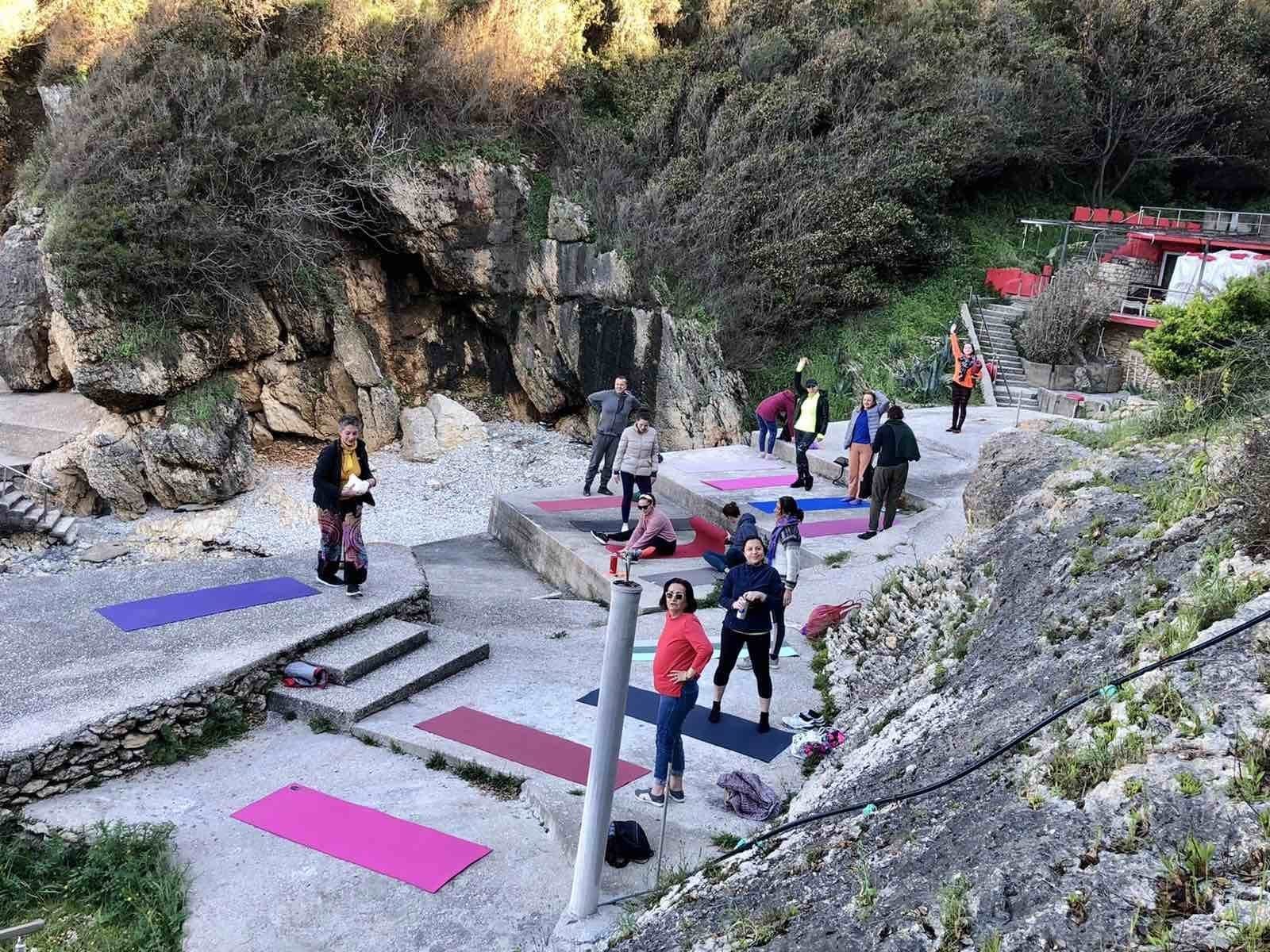 Shtroja yoga-je shumëngjyrëshe mes shkëmbinjve në një retreat të YSK-së